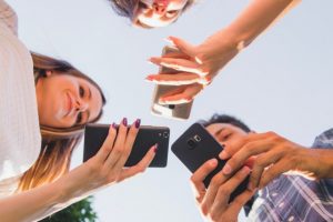 gen z youngsters checking mobile phones