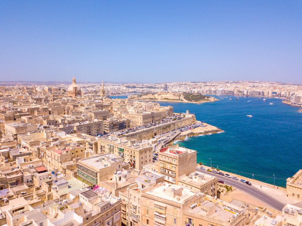 Aerial view of old town buildings near water in Valletta, Malta
